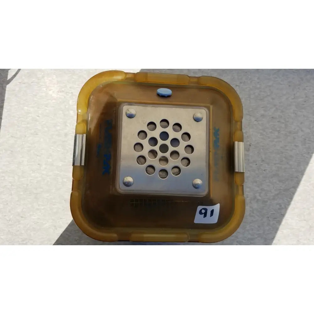 Yellow translucent plastic sterilization container with silver perforated metal insert and screws for symmetry medical flashpak
