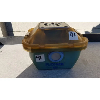 Teal and amber plastic symmetry medical flashpak 9020 sterilization container with perforated lid and blue vent