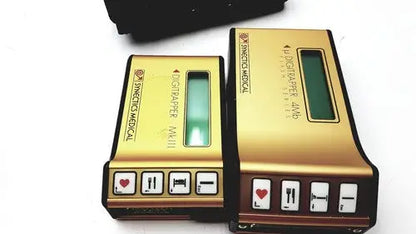 Gold-colored digital medical devices with green screens and black buttons on synectics digitrapper 4mb units
