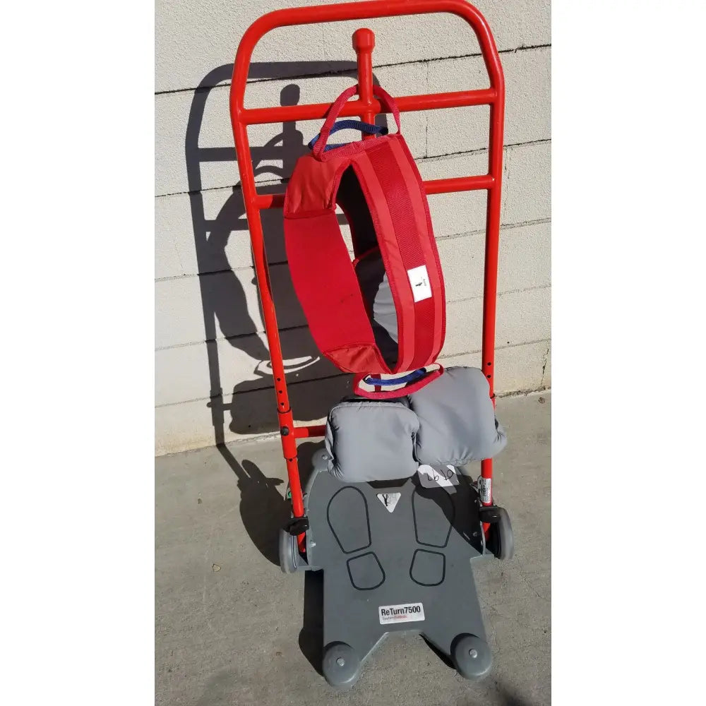 Red and gray romedic return7500 sit to stand manual lift aid with padded harness and footrests for mobility assistance