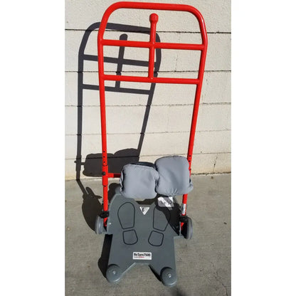 Red metal romedic return7500 sit to stand manual lift aid with gray padded seat footrest sturdy frame and four wheels