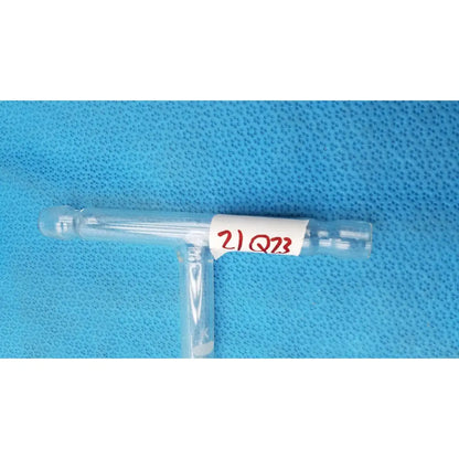 Clear plastic t-shaped hose connector tube 71mm with white label and red handwritten text for labware use