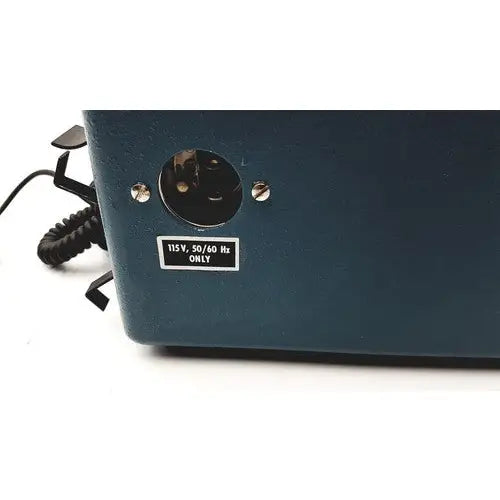 Dark teal plastic power input port with black coiled cord and silver screws on the back of teledyne portable oxygen analyzer