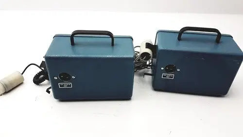Two matching blue rectangular teledyne portable oxygen analyzers with black handles and coiled cords for easy transport
