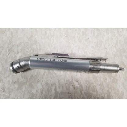 Silver metallic micro 100 drill with curved nozzle and textured grip in the case genuis serial no 9354 patent pending