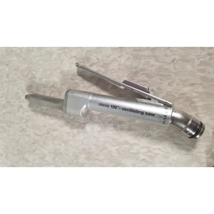 Silver metallic micro 100 inch oscillating saw with cylindrical body and trigger in the Case Genuis Serial No 9354 Patent Pending