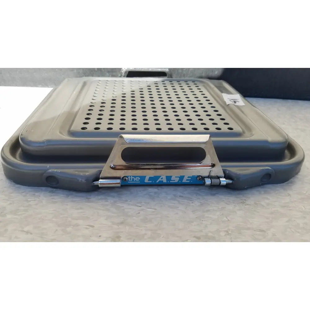 Gray plastic case sterilization container half lid black with perforated lid and metallic handle branded the case in blue lettering