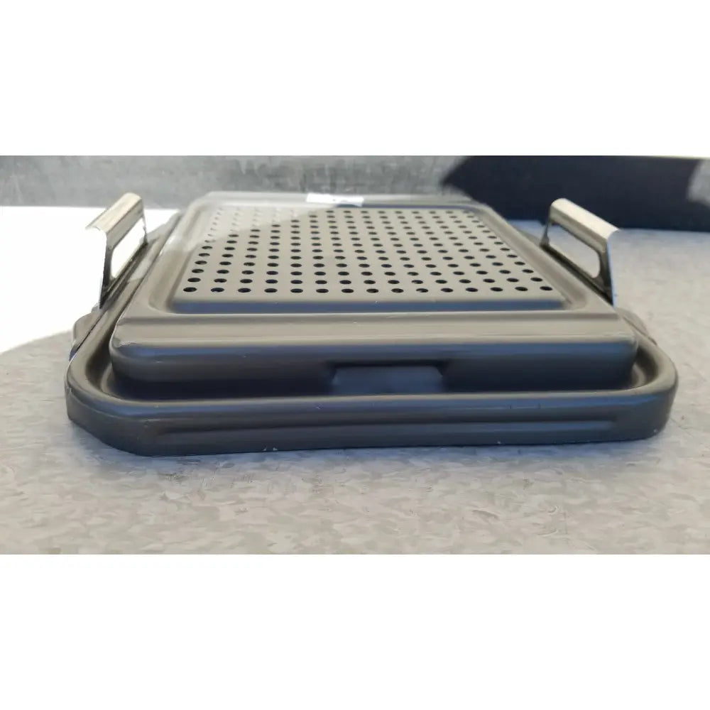 Black plastic folding grill with perforated surface and metallic handles for case sterilization container half lid use