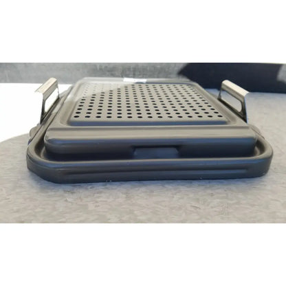 Black plastic folding grill with perforated surface and metallic handles for case sterilization container half lid use