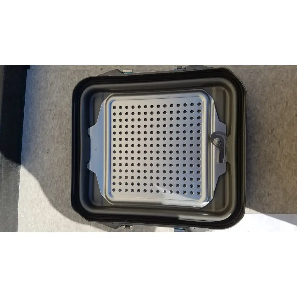 Silver perforated metal grilling plate with reinforced edges for case sterilization container half lid black