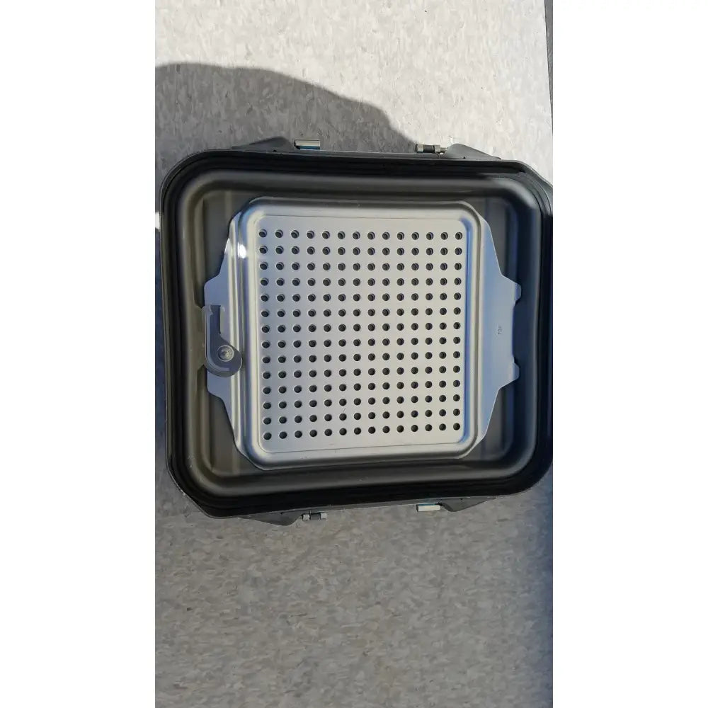 Black plastic case sterilization container half with silver perforated metal grilling tray and container half lid