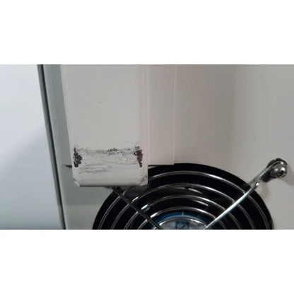 White painted corner of the silent solution silencer 2210 centrifuge system cabinet with chipped paint above black fan grille