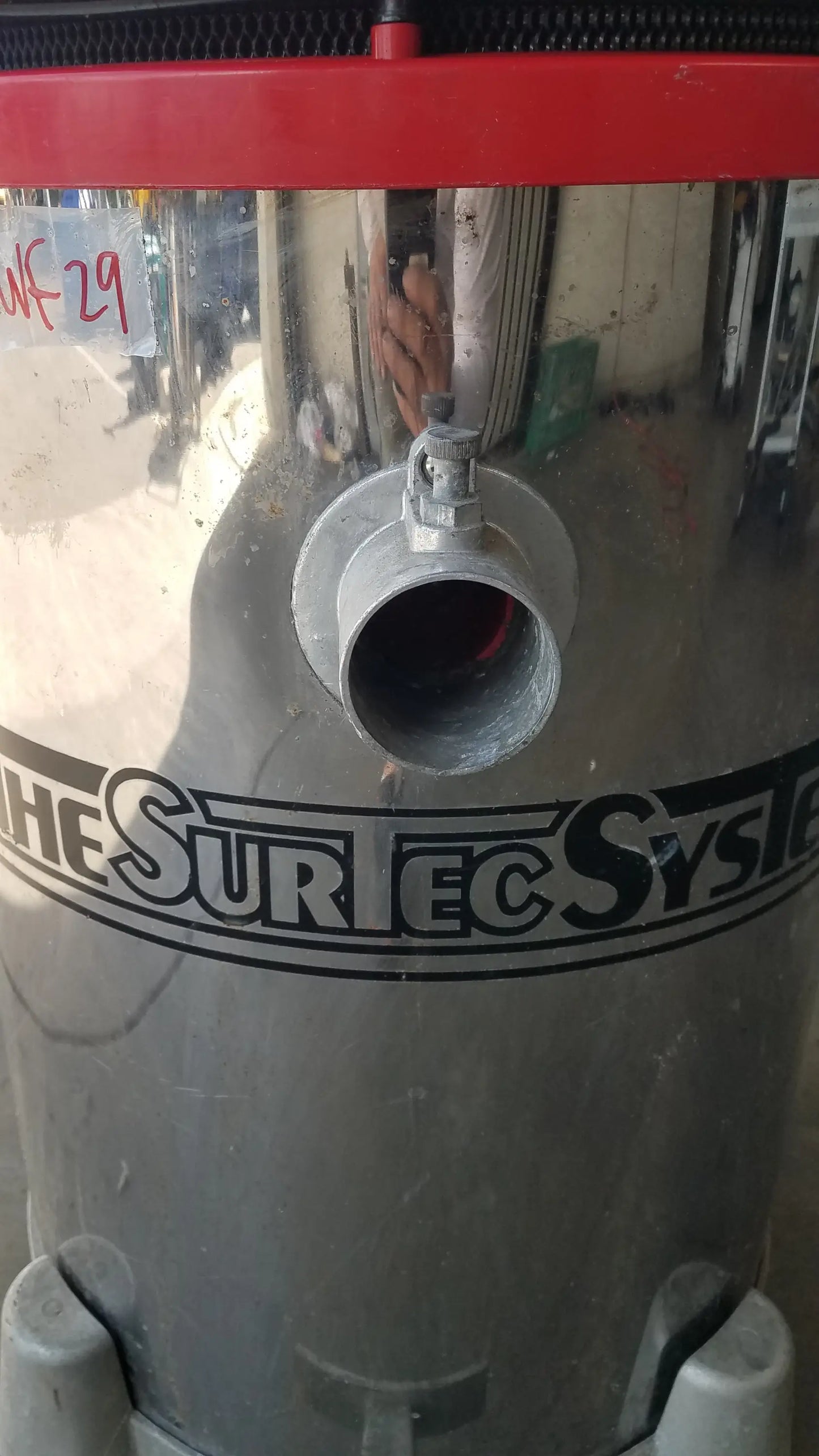 The Surtec System 450M silver cylindrical heavy duty wet dry drum vacuum cleaner with red top and black branding