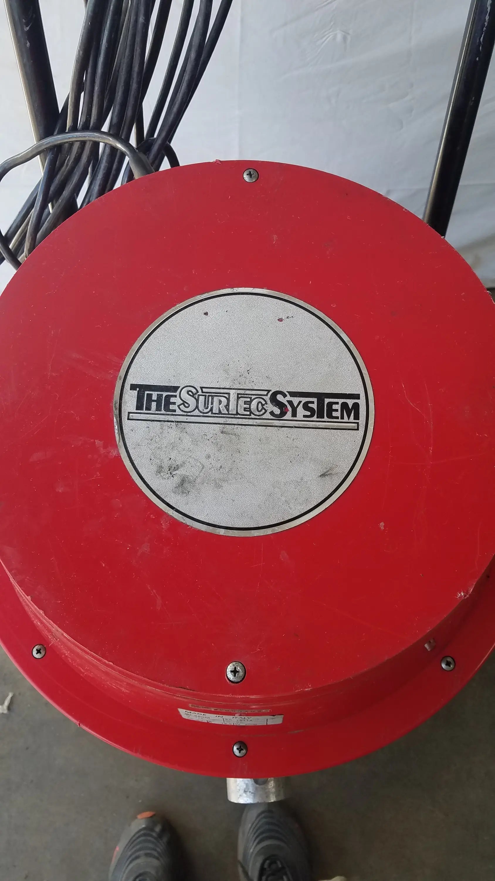 Red circular wet dry drum vacuum with the sureco system logo on a silver center plate for industrial use