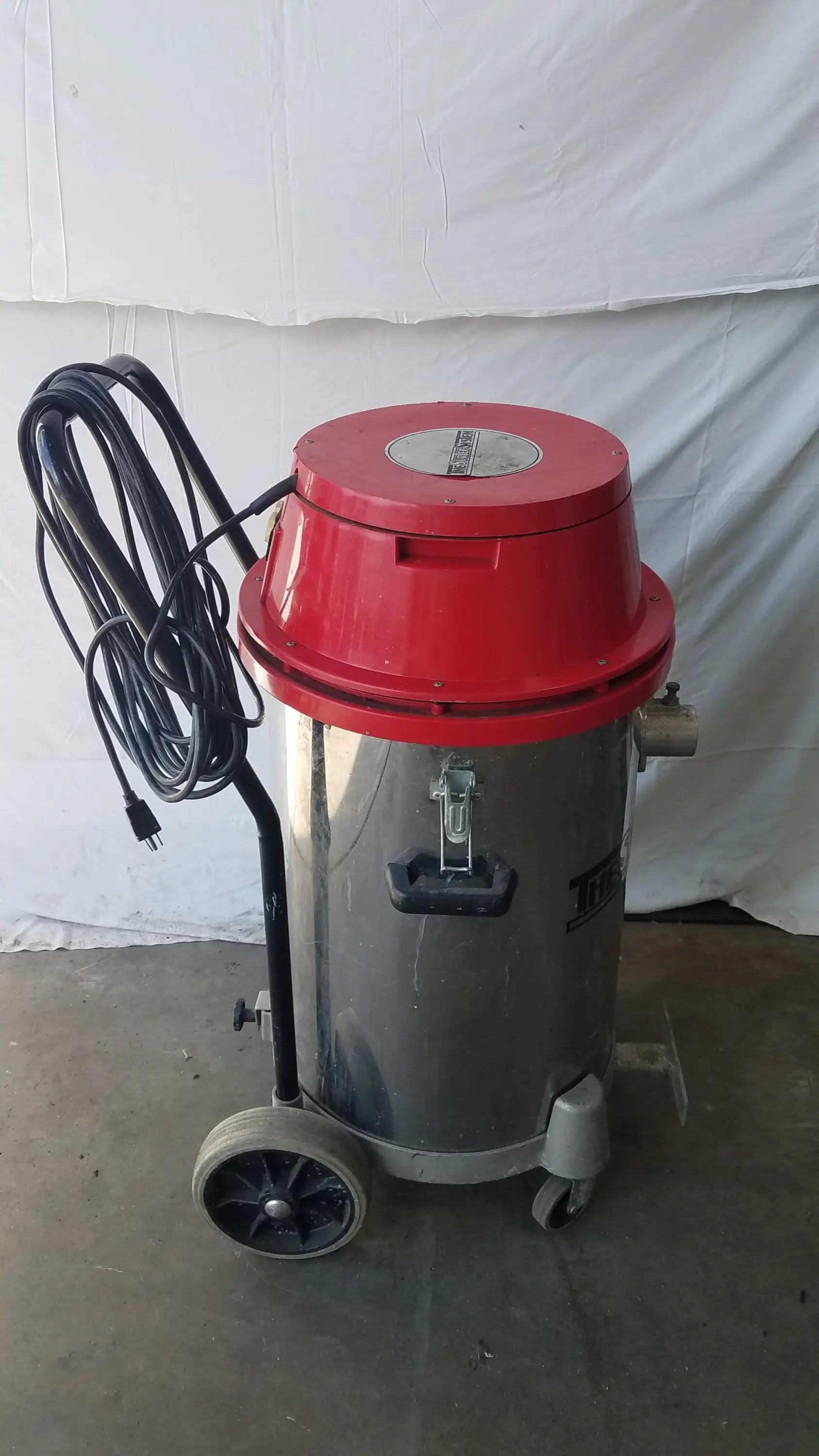 The surtec system 450m red and silver wet dry drum vacuum with cylindrical tank, black handle, and wheels for industrial use