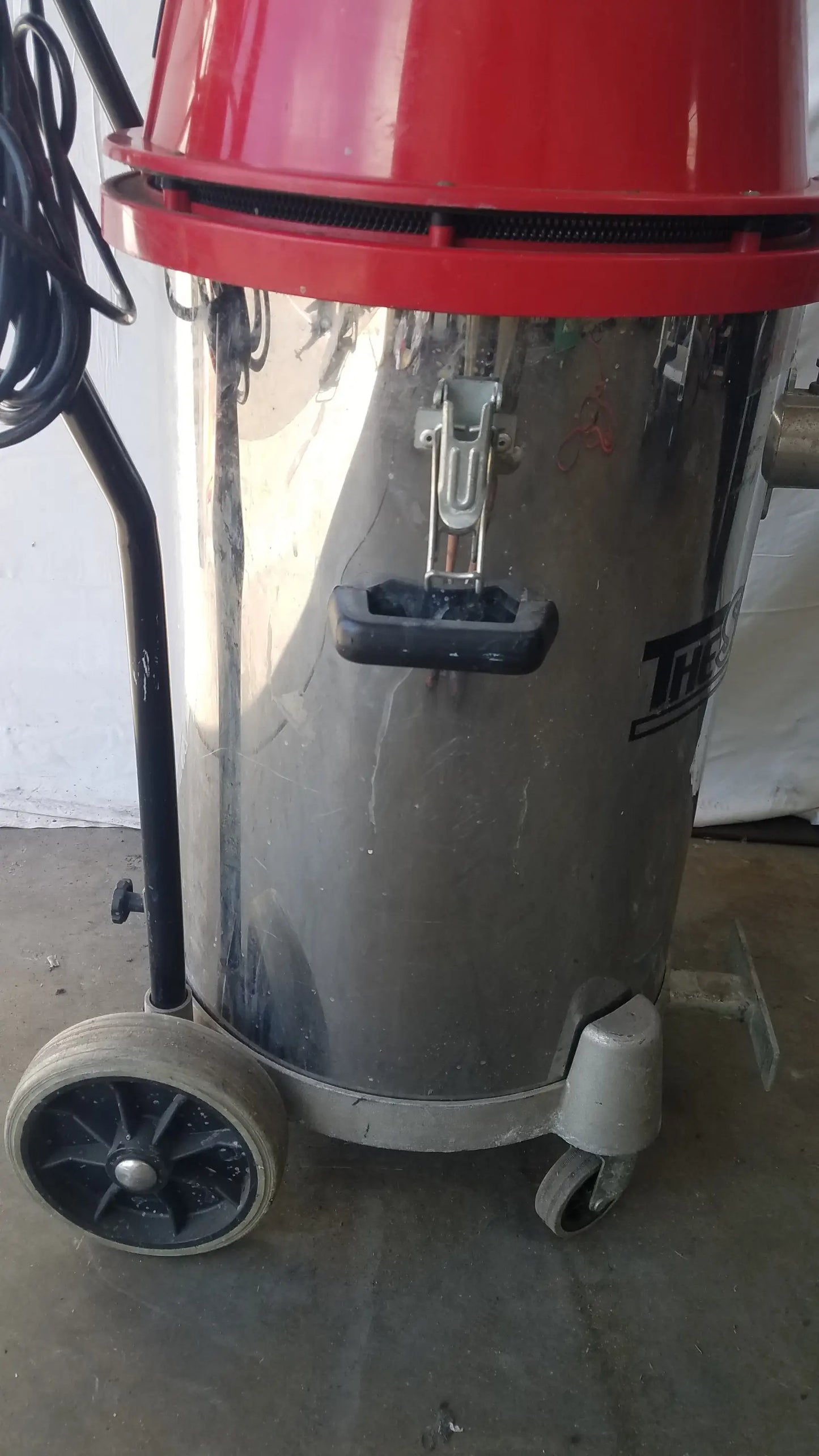 The surtec system 450M industrial heavy duty red and silver wet dry drum vacuum cleaner with handle and wheels