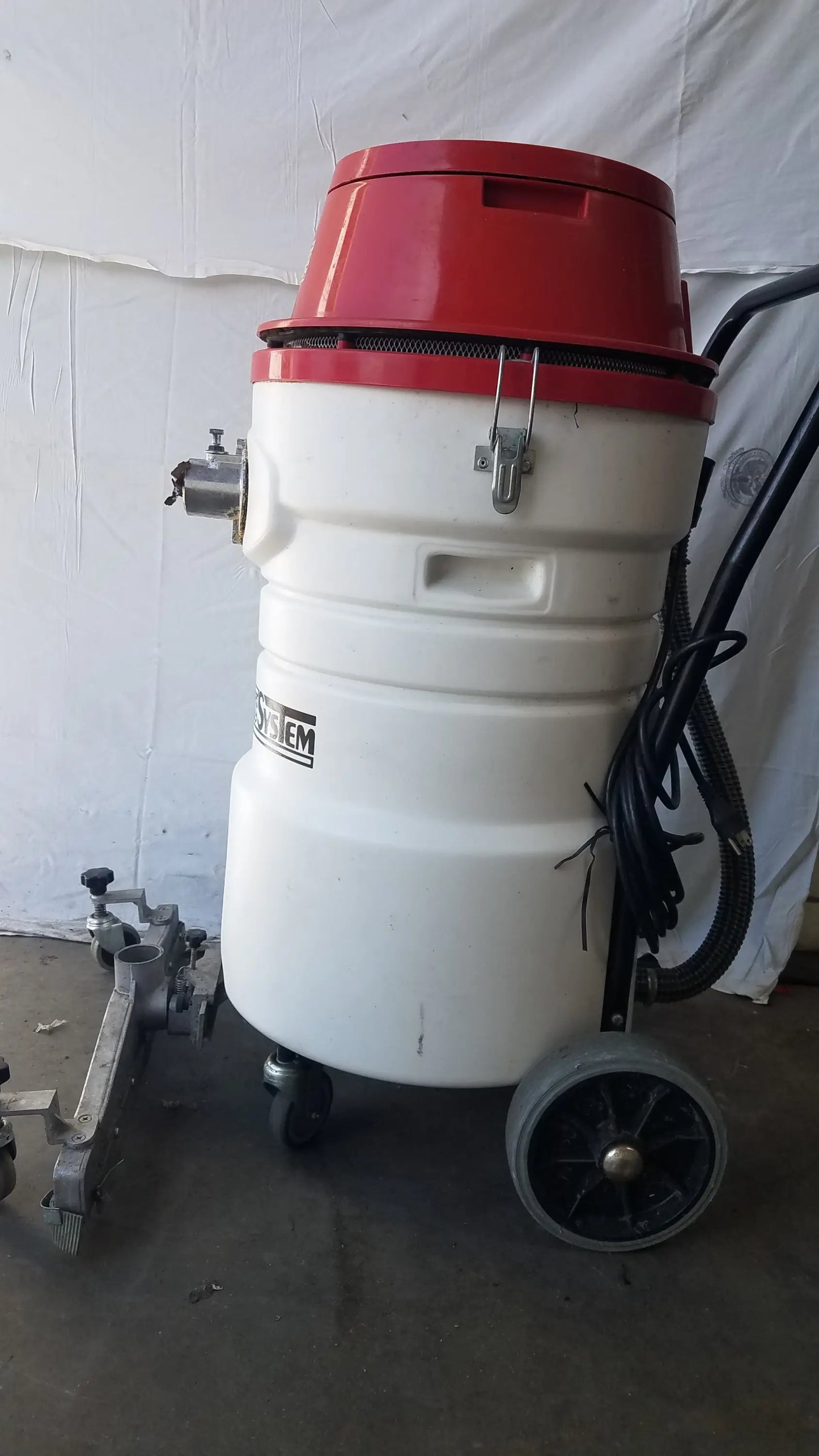The Surtec System C72F1 red and white wet dry vacuum cleaner with cylindrical body and black wheels and hoses