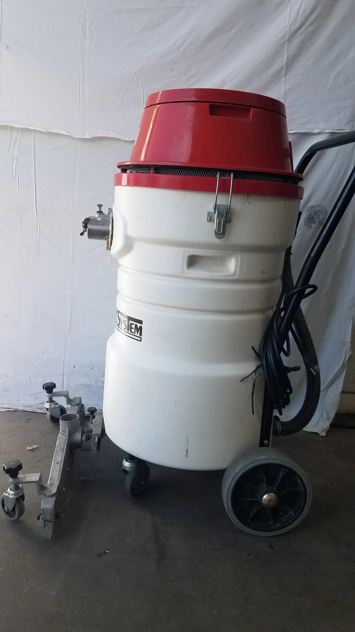 The Surtec System C72F1 red and white wet dry vacuum cleaner with cylindrical body, black wheels, and attached hoses