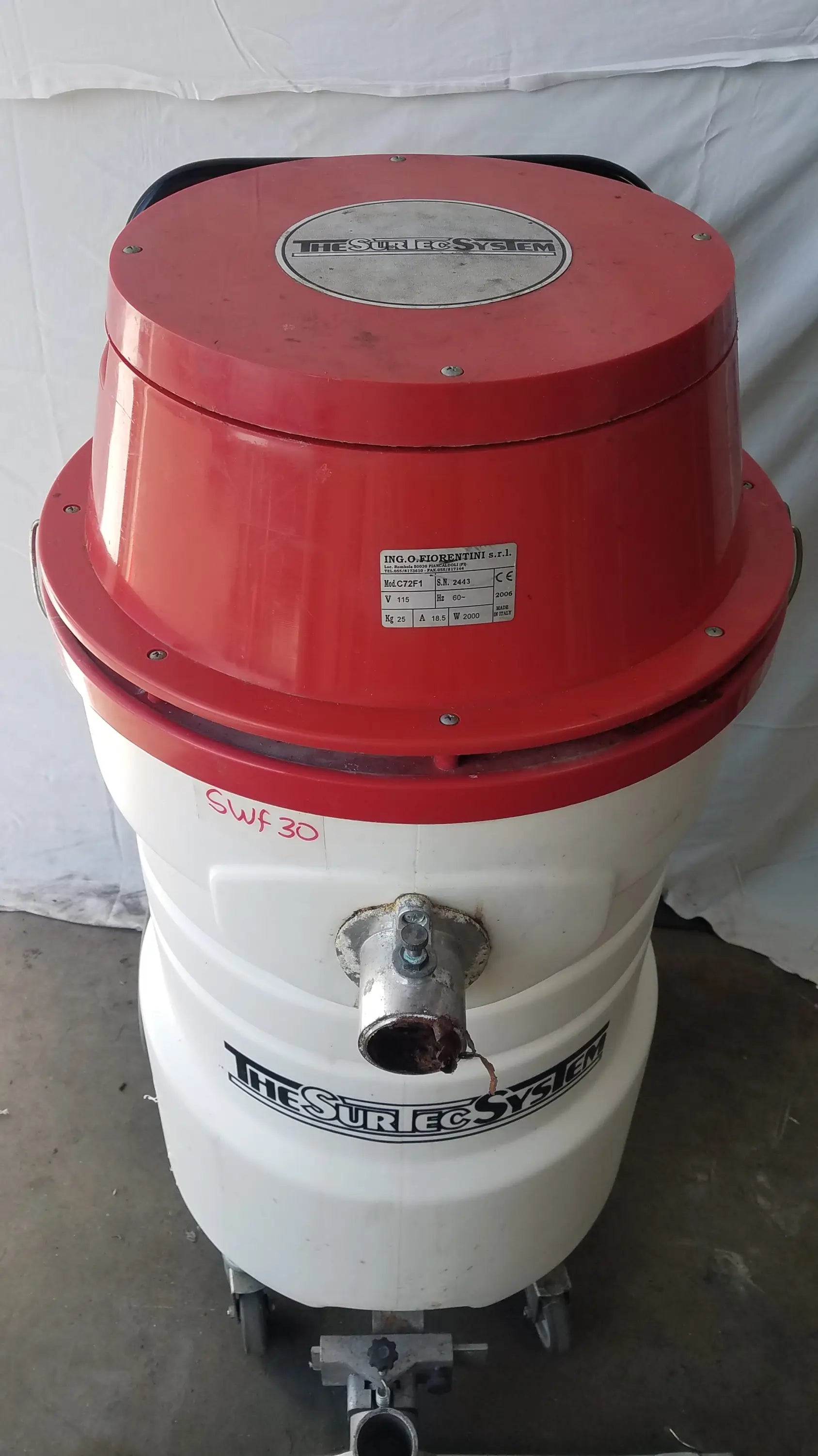 The surtec system c72f1 red and white wet dry vacuum cleaner with cylindrical metal body and wheels for mobility