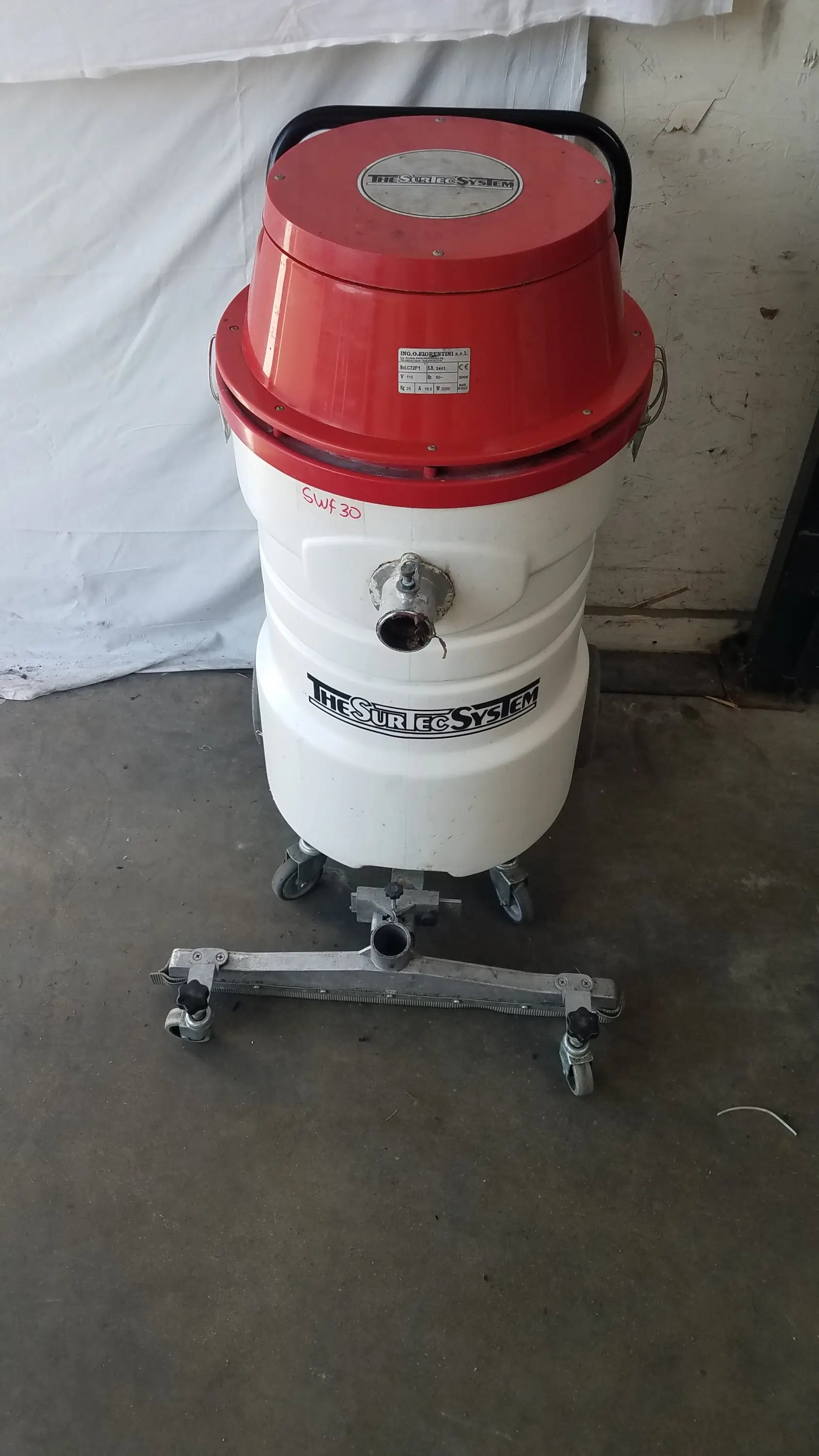 The surtec system c72f1 wet dry vacuum cleaner 115v with red and white cylindrical body and metal caster wheels