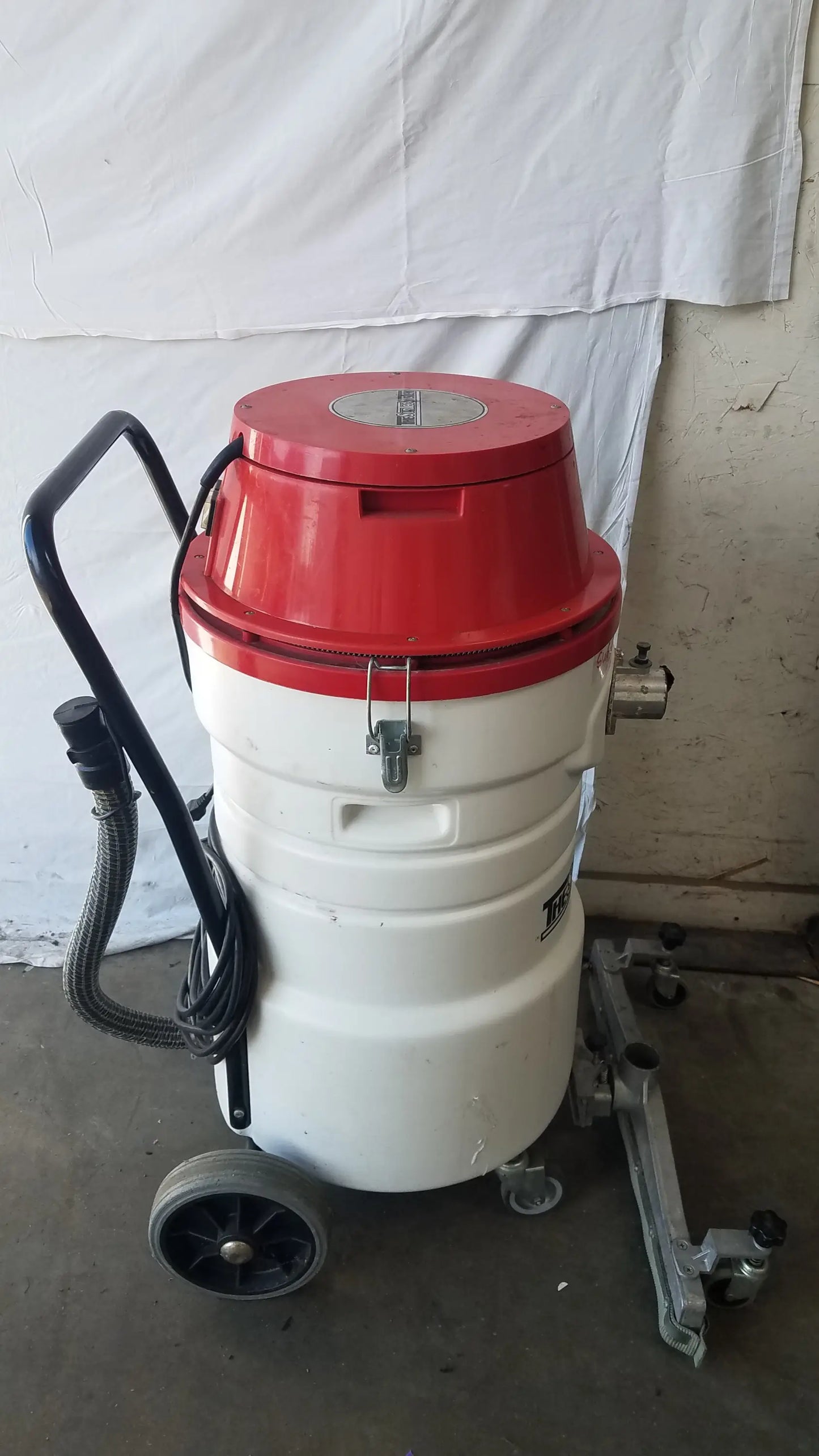 The Surtec System C72F1 red and white wet dry vacuum cleaner with black handle and wheels for industrial use