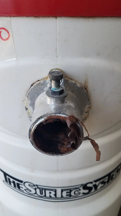 White cylindrical wet dry vacuum tank with rusted pipe and knob featuring the surtec system branding back side view