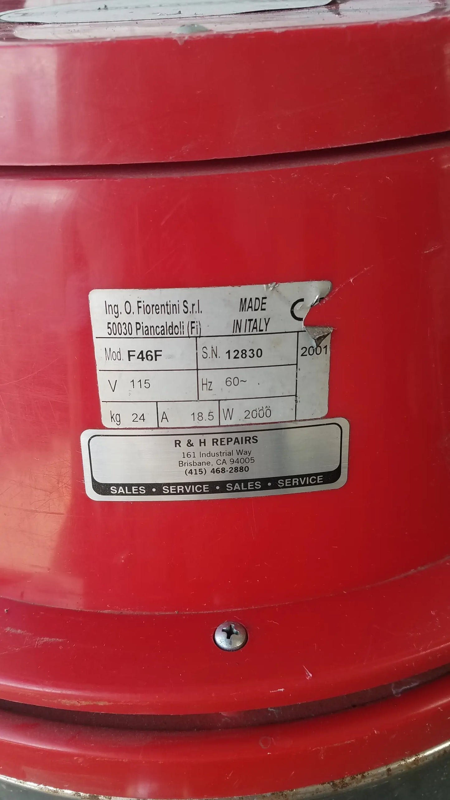 Red industrial fan with metallic label showing specifications on the back of the Surtec System F46F wet dry drum vacuum