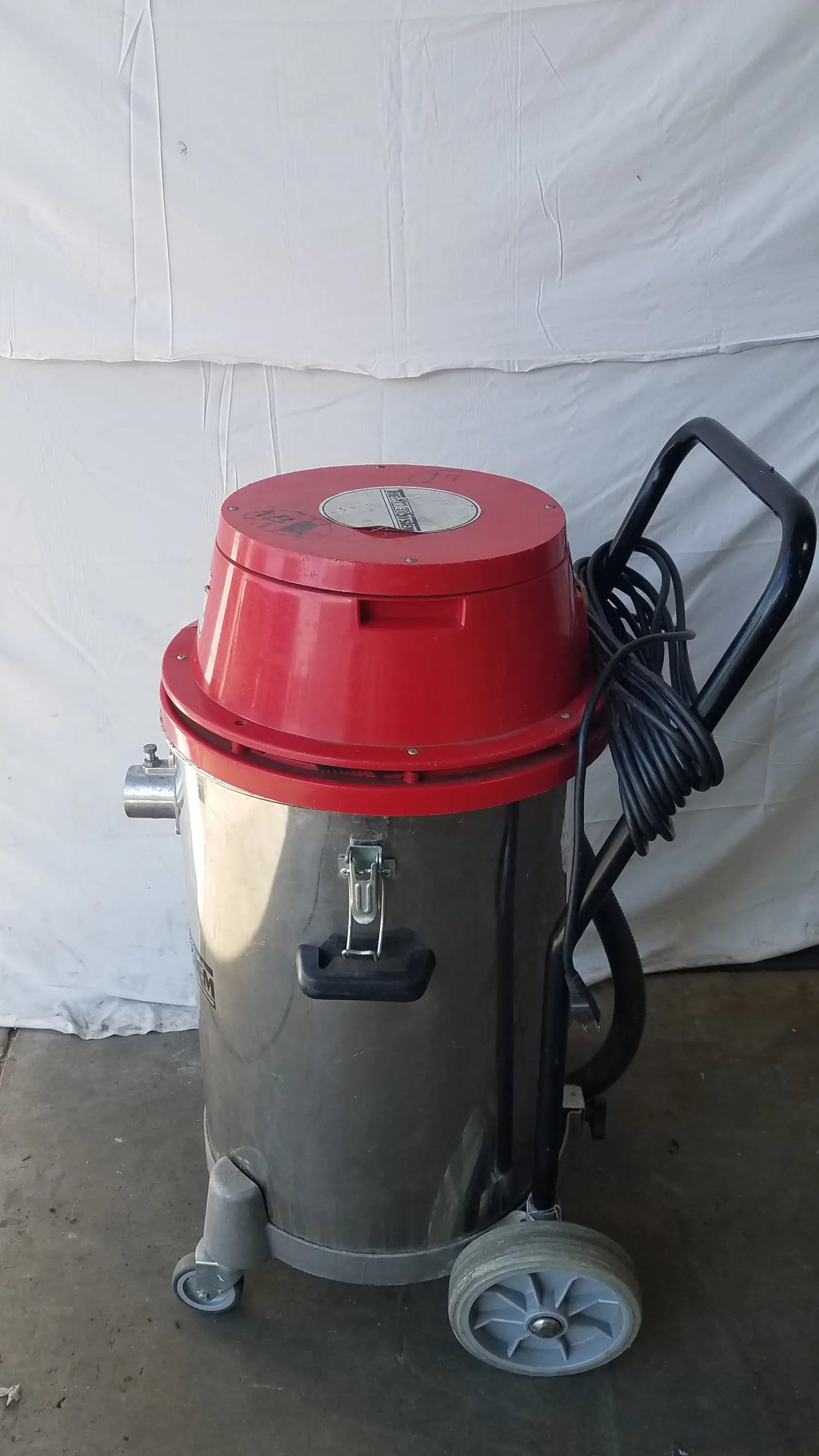 Red and silver surtec system f46f wet dry drum vacuum cleaner with black handle coiled hose and gray wheels