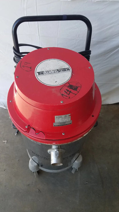 Red and gray industrial wet dry drum vacuum with black handle branded the sure and system on lid for heavy duty use