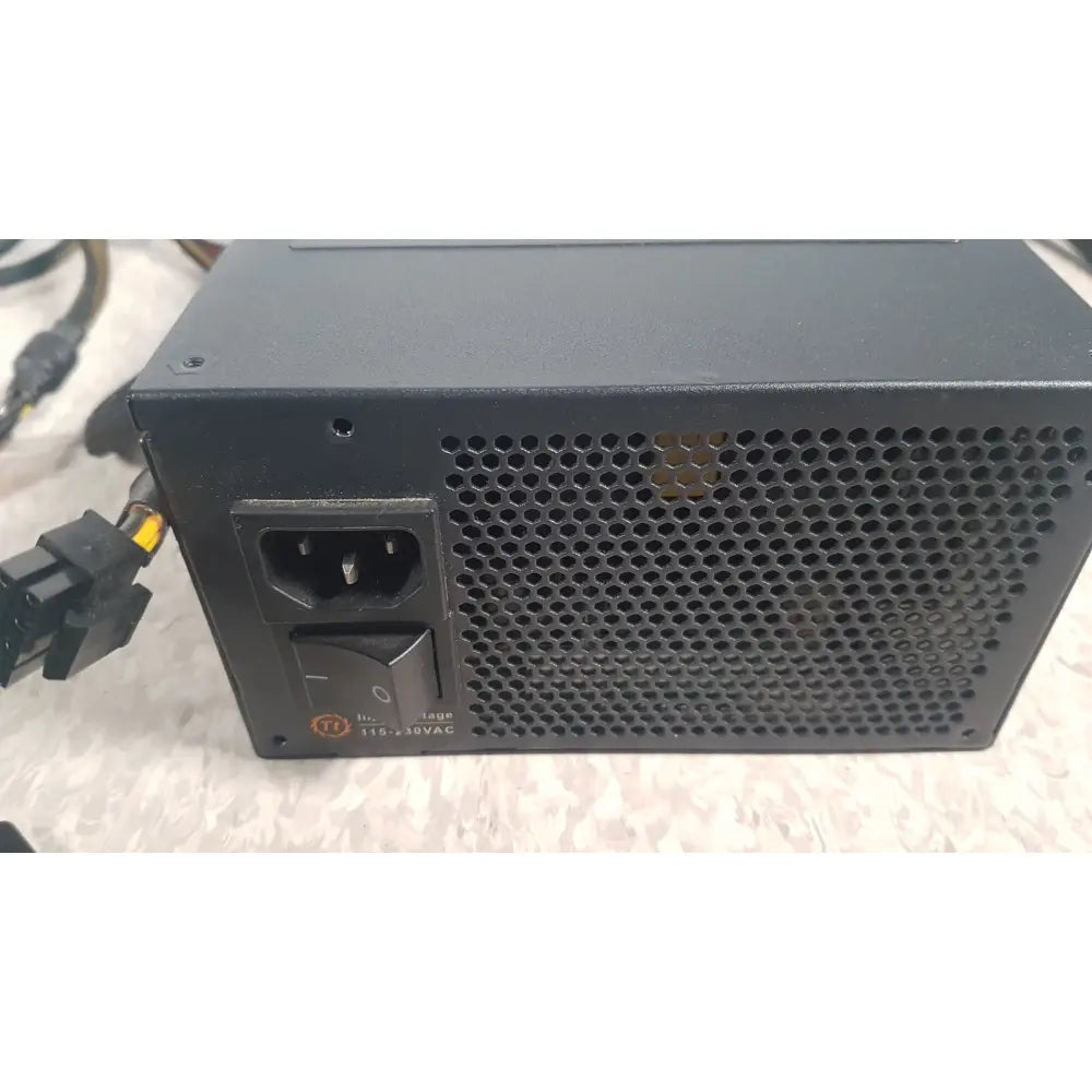 Black thermaltake 1350w toughpower gf3 1350w full modular power supply with a perforated metal grille and ac input port
