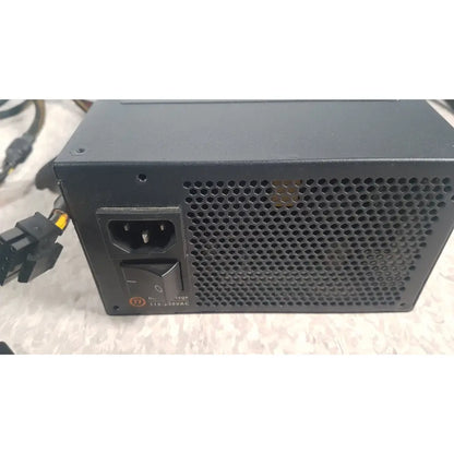 Black thermaltake 1350w toughpower gf3 1350w full modular power supply with a perforated metal grille and ac input port