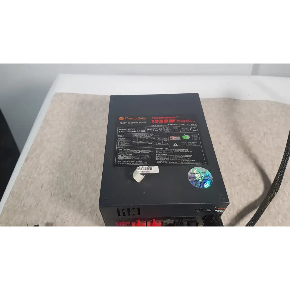 Black thermaltake 1350w toughpower gf3 full modular power supply with red white labeling holographic sticker and visible cables