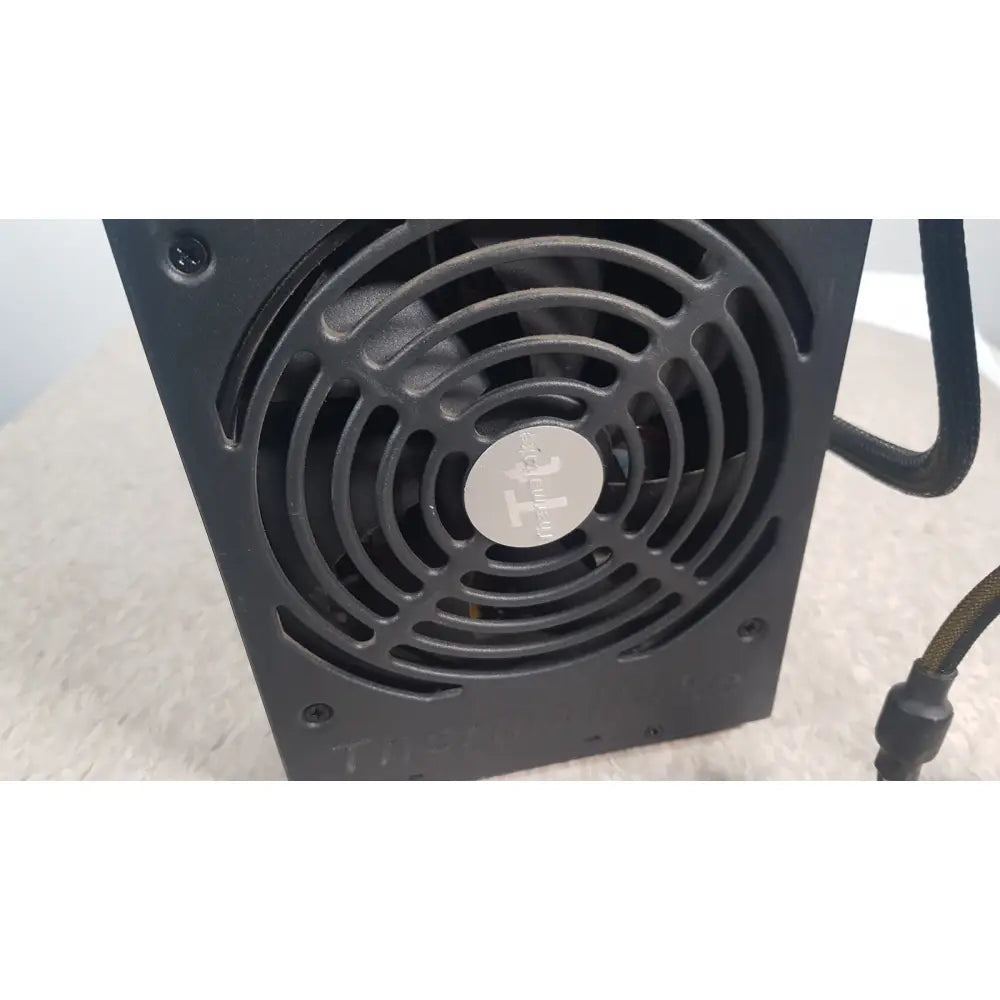 Black rectangular thermaltake 1350w toughpower gf3 full modular power supply with circular fan and silver logo plate