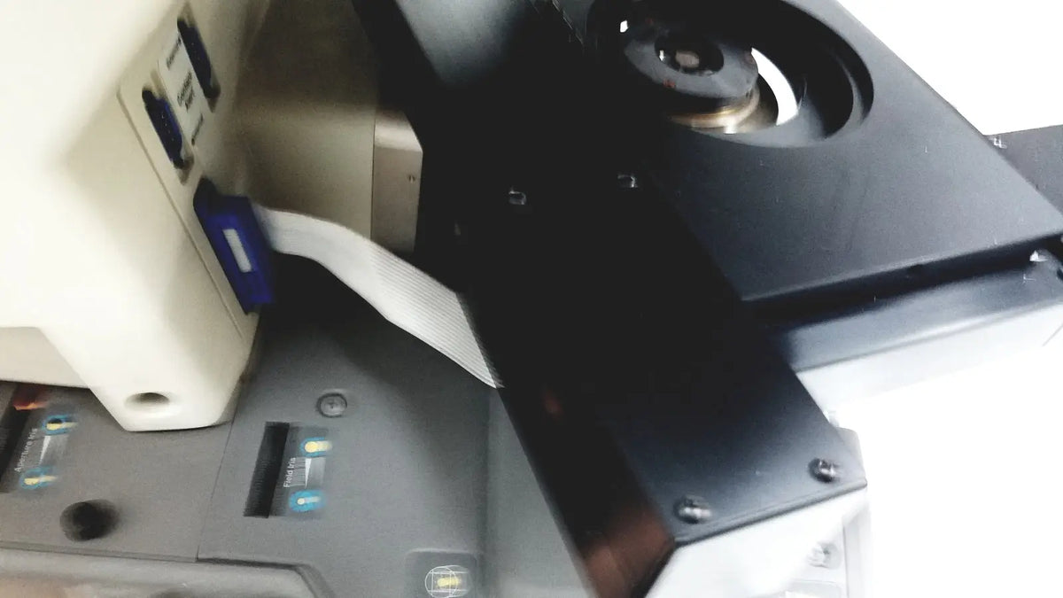 Black plastic component with circular cutout and metallic screws on the back side of thermo nicolet continuum infrared microscope
