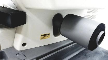 Gray cylindrical lens housing with black end caps mounted on white base of thermo nicolet continuum infrared microscope