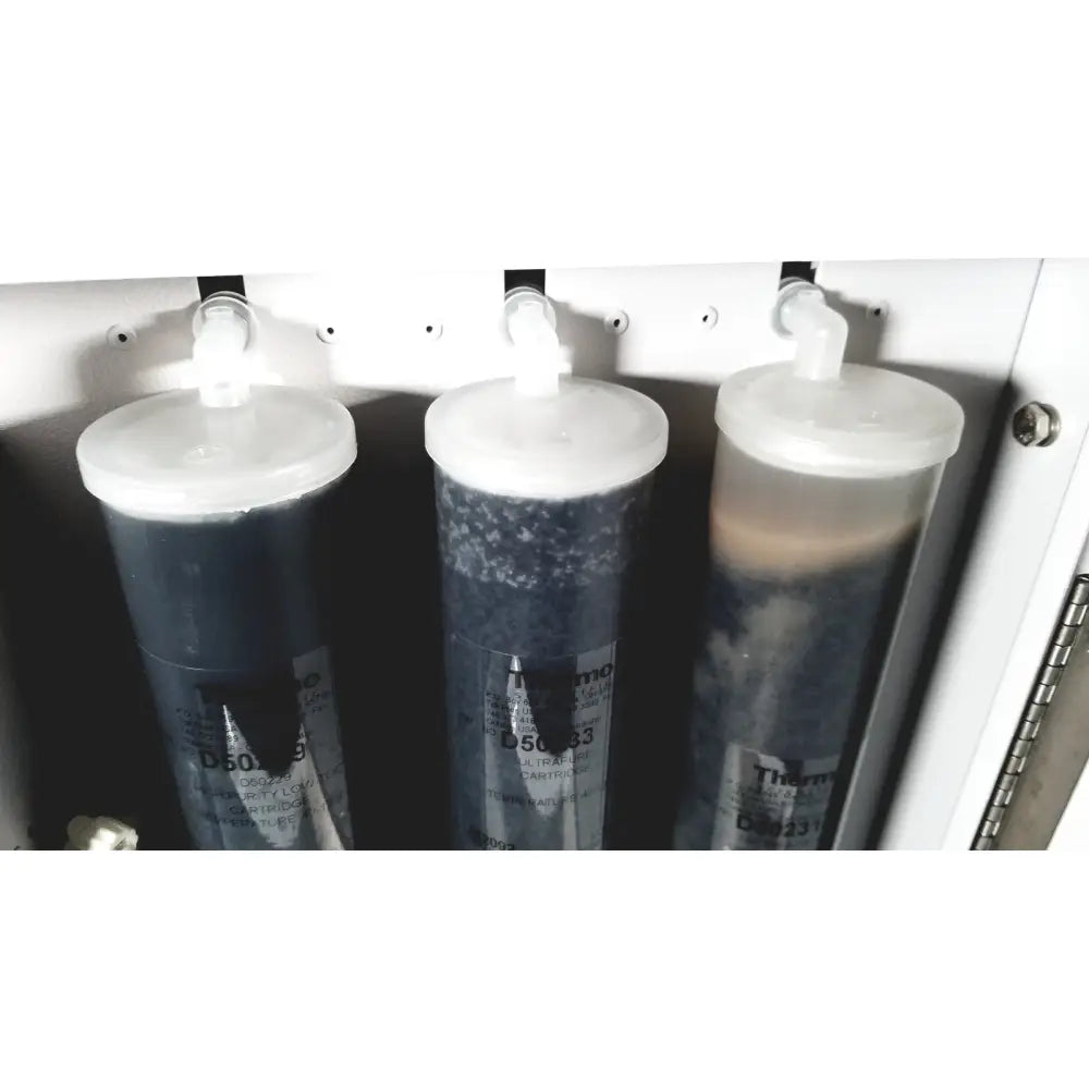 Three translucent cylindrical thermo scientific easypure ii d7401 d5063 cartridges with dark sediment for lab grade filtration