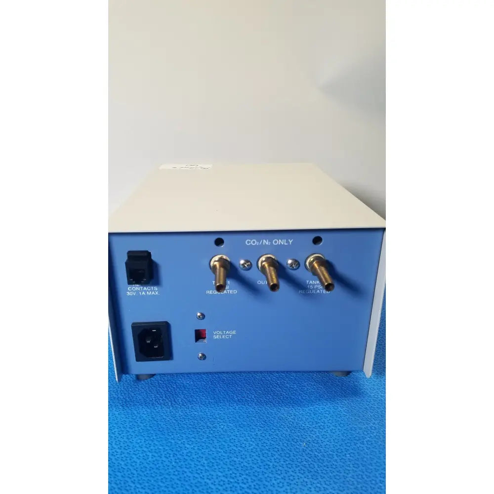 Blue rectangular thermo scientific gas guard model 3050 with brass gas output ports and black power input socket shown from back