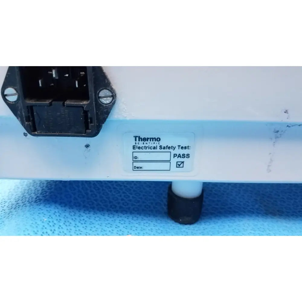 White plastic electrical safety pass label on thermo scientific linistat linear slide stainer appliance side