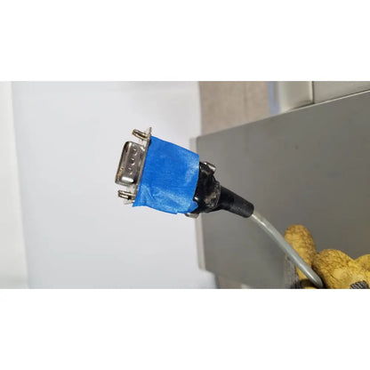 A blue-taped db9 serial connector with metallic pins and black cable on the back side of thermo scientific microm hm 340e