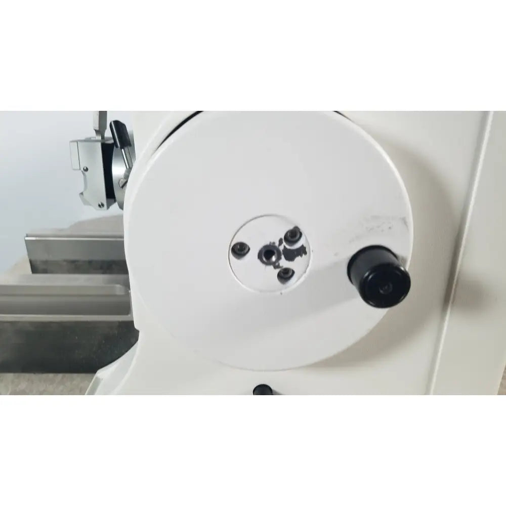 White circular machine component with black threaded holes and knob on thermo scientific microm hm 355 s rotary microtome