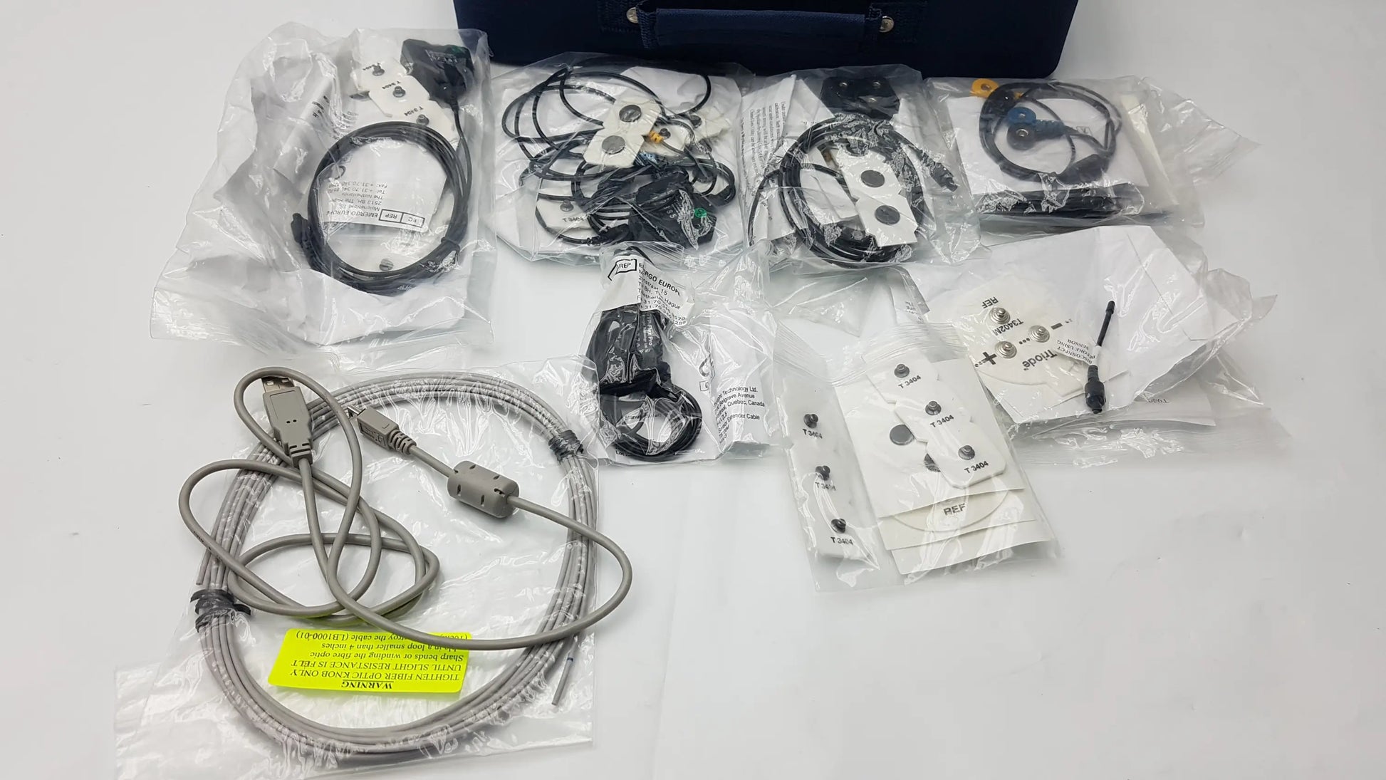 Gray coiled usb cable with metallic connectors and yellow label for thought technology physiological data acquisition device