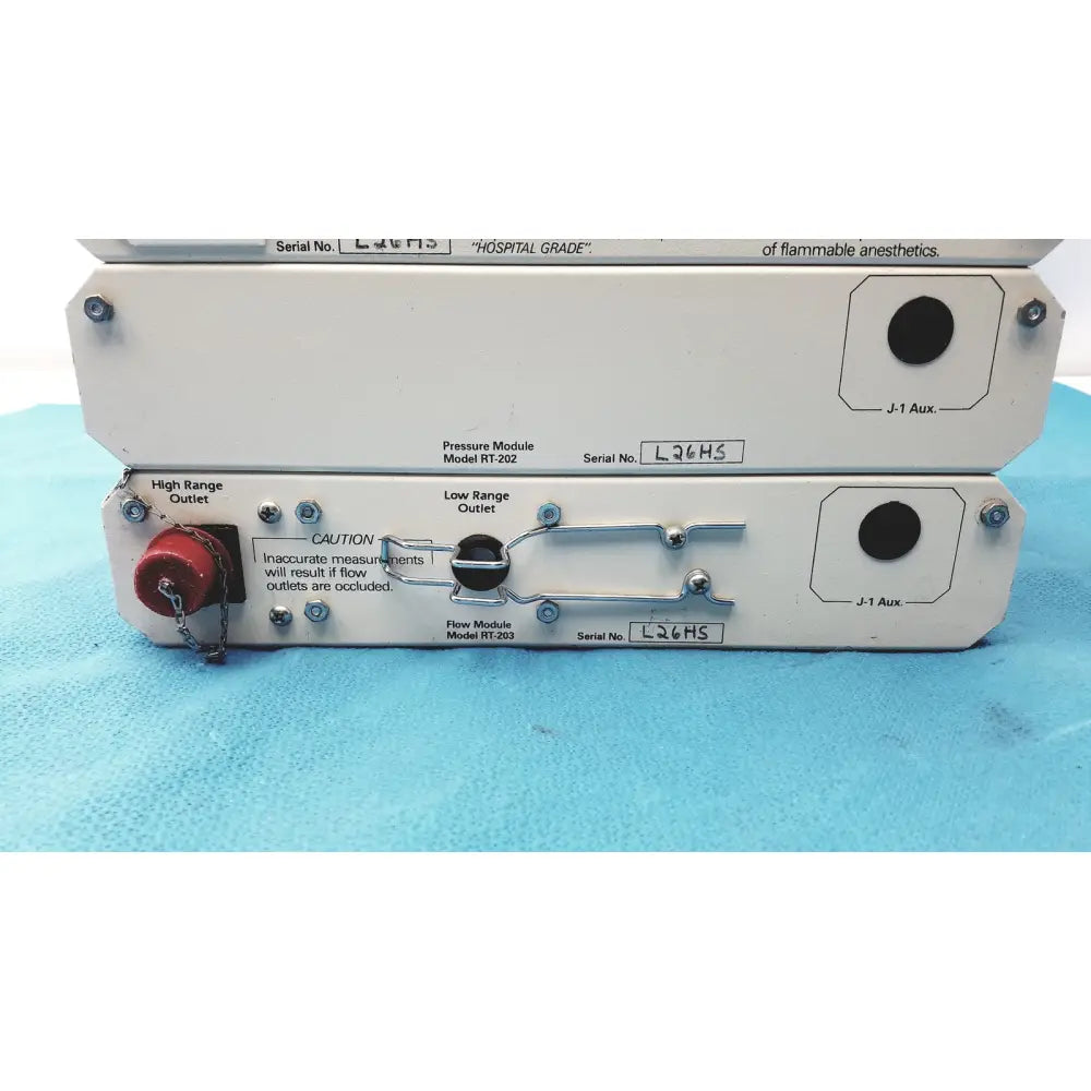 White medical pressure and flow modules with red outlet cap labeled hospital grade from timeter instrument corporation rt-200 analyzer