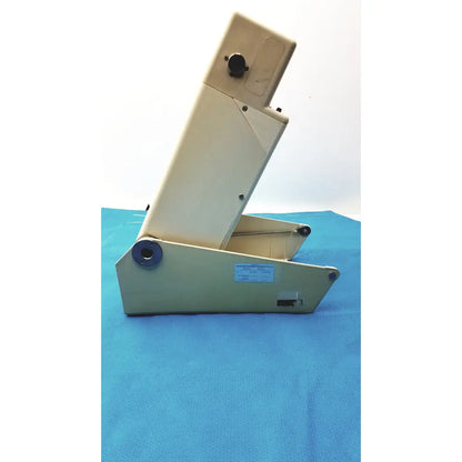 Beige plastic document feeder with black circular parts and blue base for titmus optical titmus ii vision tester with controller