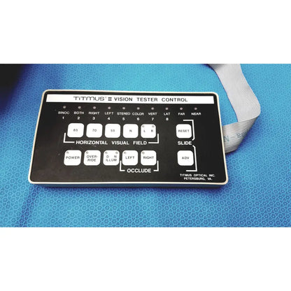 Black titmus optical titmus ii vision tester control panel with white labeled buttons and silver ribbon cable