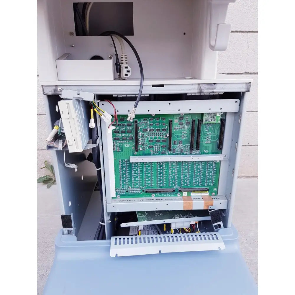Green circuit board with black memory slots and silver connectors inside gray enclosure of toshiba nemio ultrasound machine missing parts