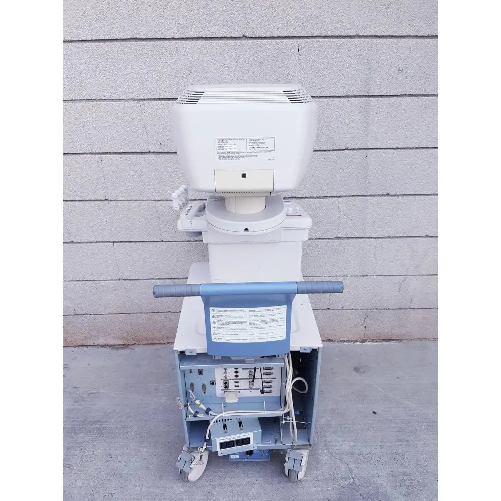 White and blue toshiba nemio 10 ultrasound machine with a wheeled cart base missing parts as-is view of front side