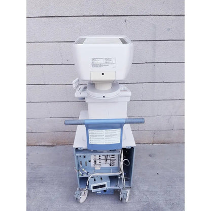 White and blue toshiba nemio 10 ultrasound machine with a wheeled cart base missing parts as-is view of front side