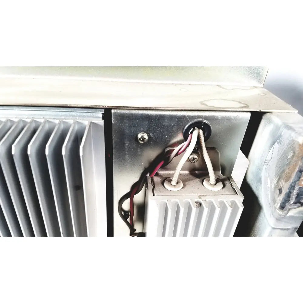 Silver metallic heat sink with vertical fins and wiring harnesses on the back of toshiba ra power rad92-1008 power supply