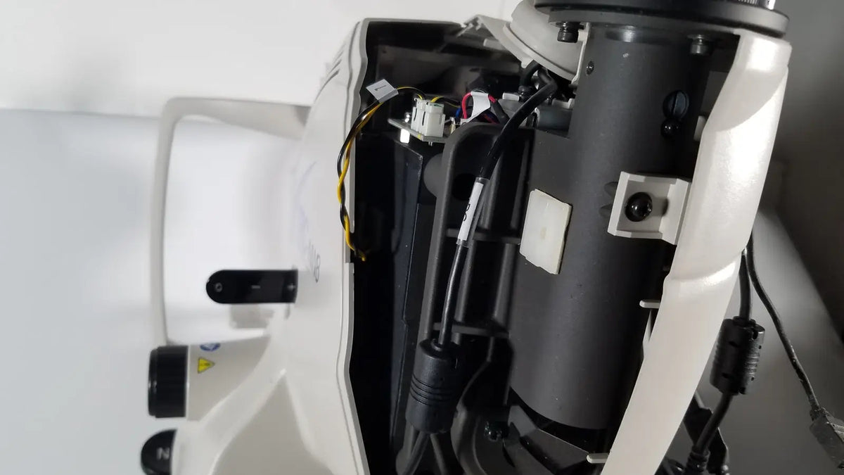 White and black industrial microscope with exposed wiring from the tracey itrace visual function analyzer wsl524m model