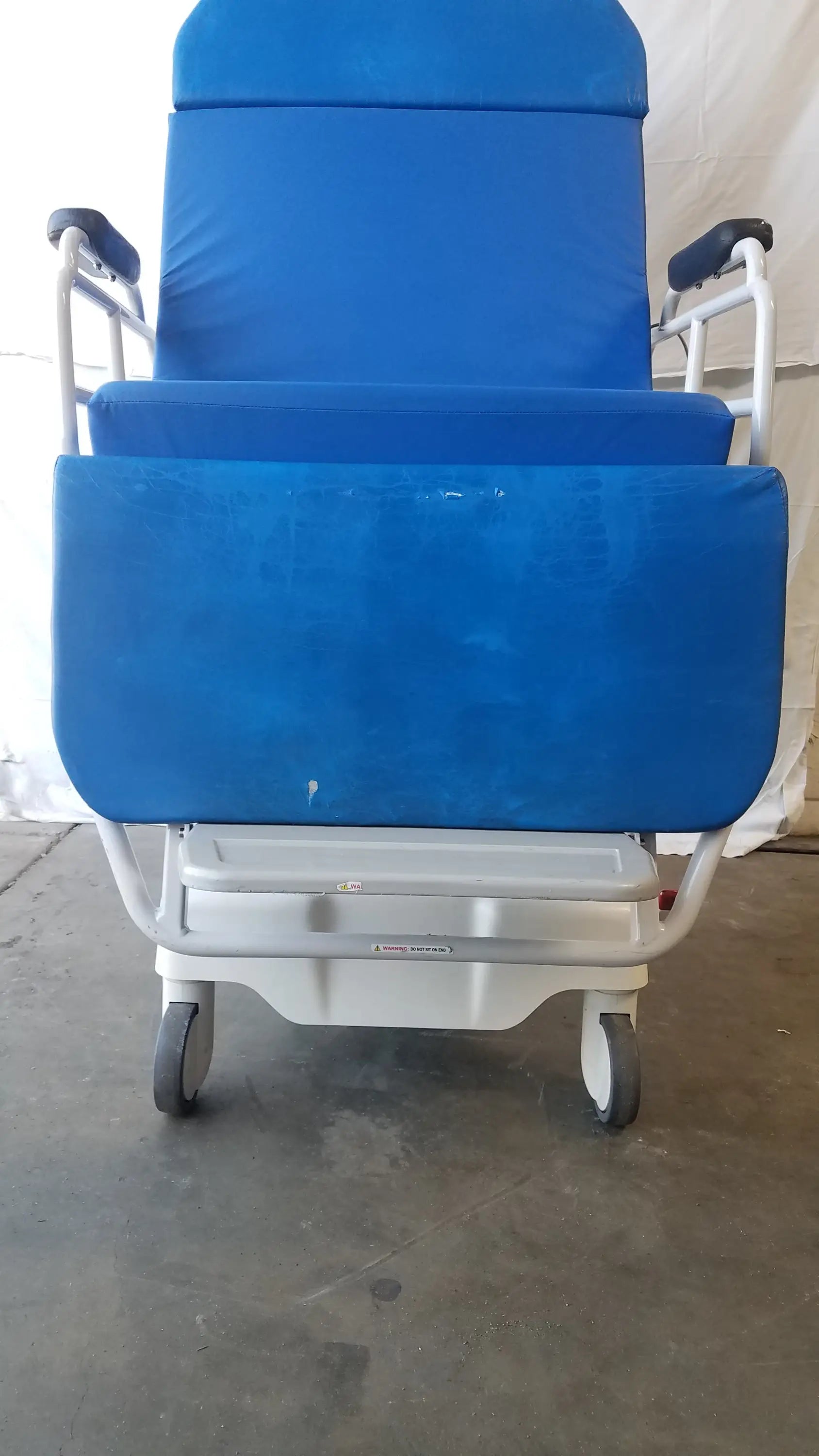 Blue upholstered TransMotion Medical TMM4 multi purpose stretcher chair with white metal frame and wheels